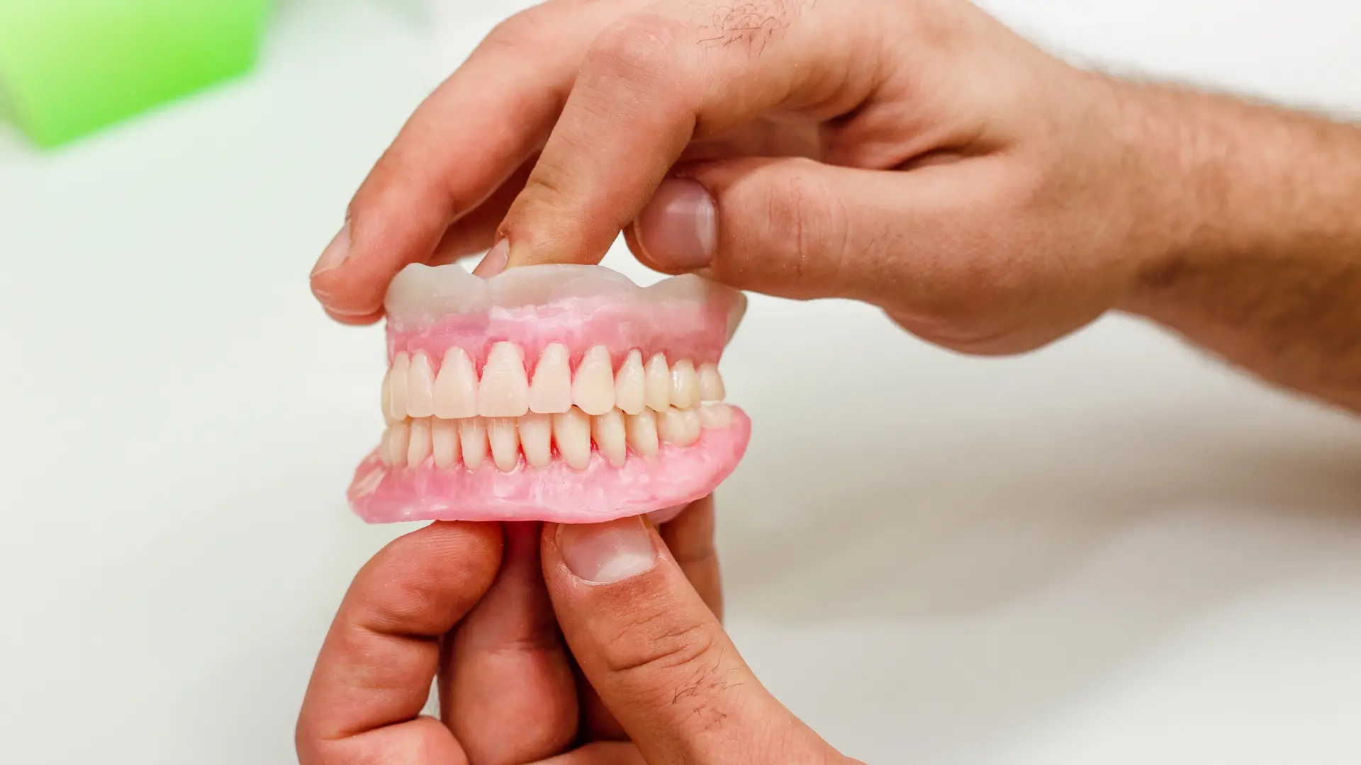 dentist holding dentures in Sugar Land